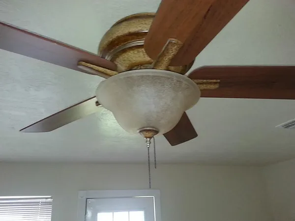 an empty room with a window and a fan