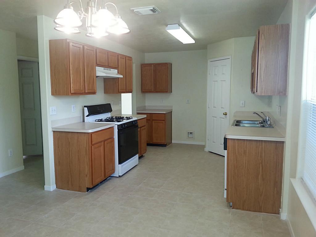 23319 Cape Cottage Court Spring, TX 77373 - Photo 10 of 23 a kitchen with stainless steel appliances a sink stove and cabinets