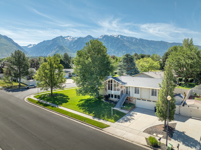 2088 Falcon Way Sandy, UT 84093 - Photo 2 of 46 Split-level residence featuring a prominent sunroom with large windows, an attached two-car garage, and a concrete driveway