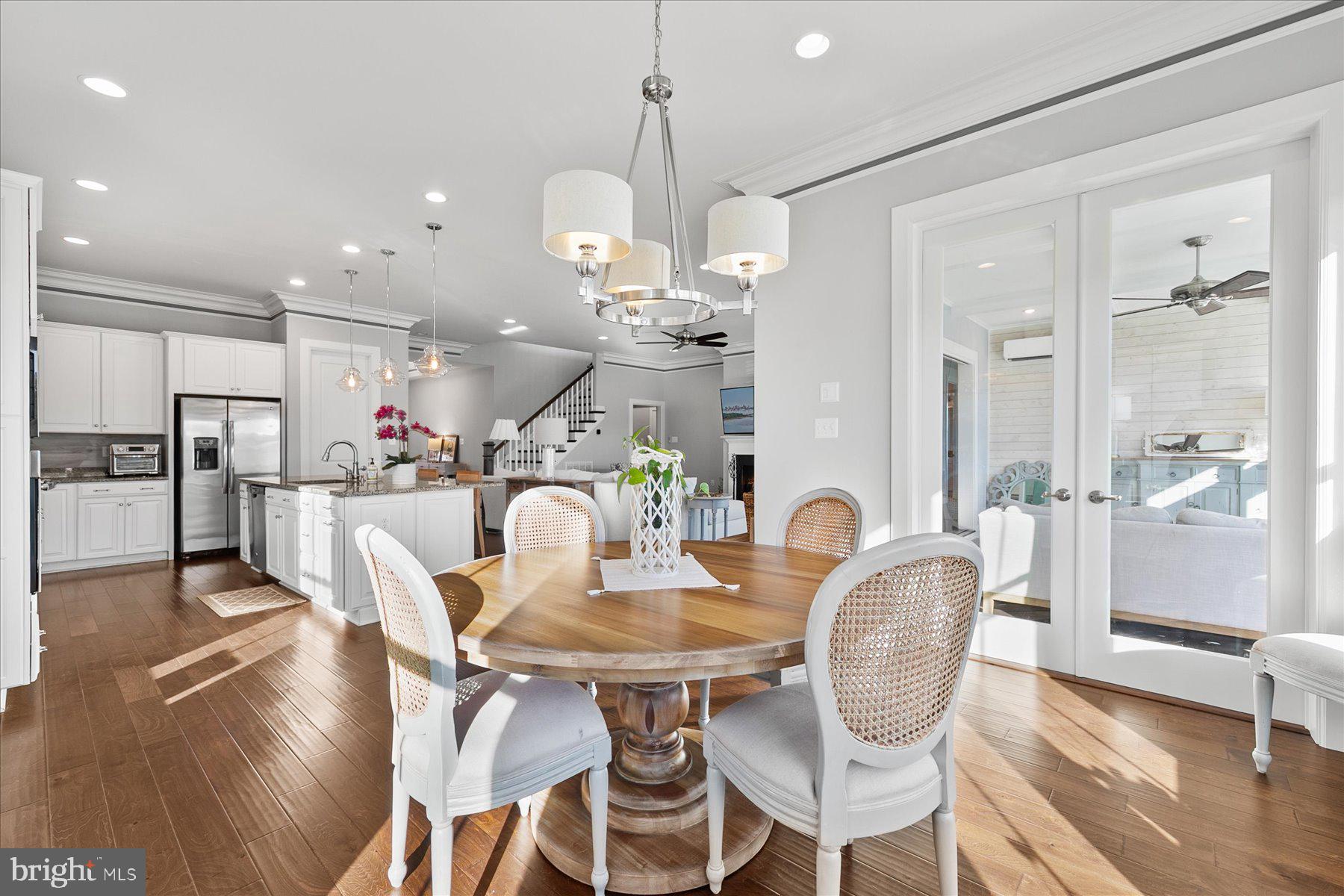 20822 Cormorant Way Ocean View, DE 19970 - Photo 13 of 91 a dining room with furniture a chandelier and wooden floor