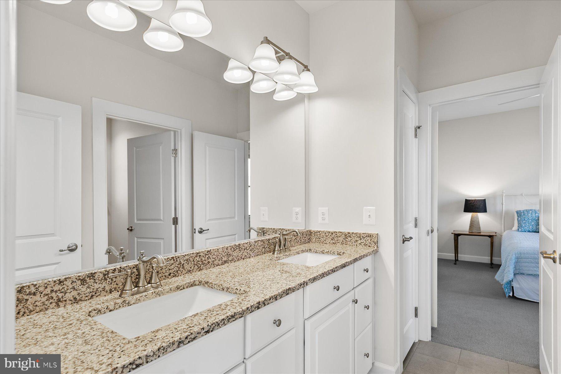20822 Cormorant Way Ocean View, DE 19970 - Photo 31 of 91 a bathroom with a granite countertop sink and a mirror
