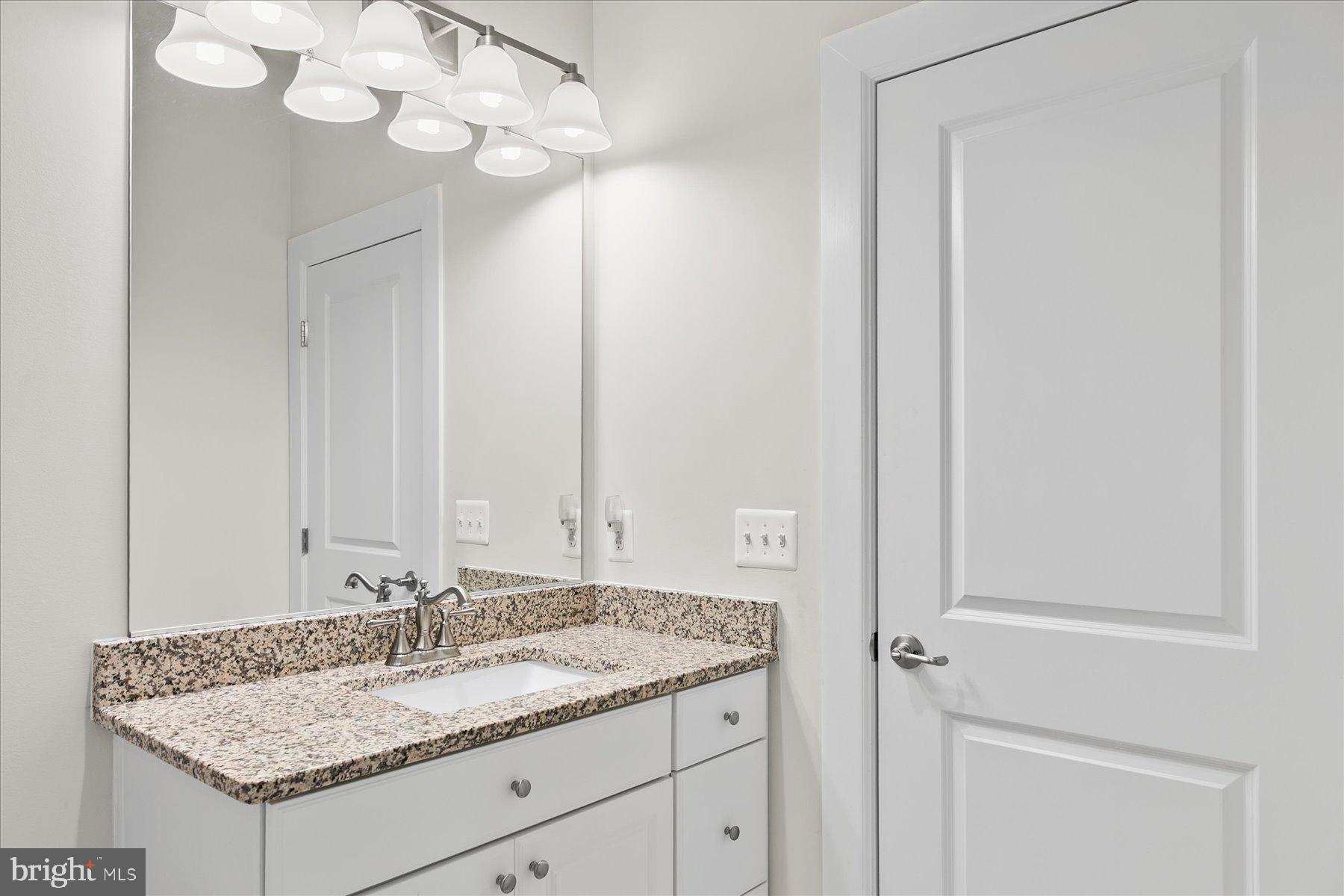 20822 Cormorant Way Ocean View, DE 19970 - Photo 37 of 91 a bathroom with a granite countertop sink and a mirror