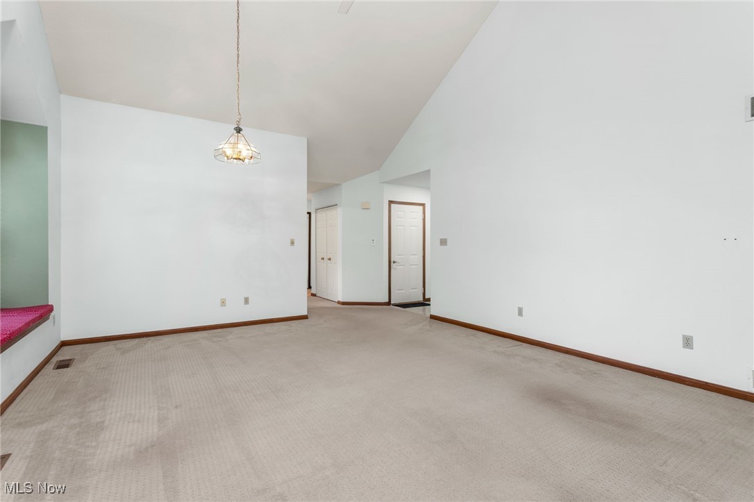 2155 Abbey Road Akron, OH 44312 - Photo 10 of 31 Carpeted empty room featuring high vaulted ceiling and baseboards