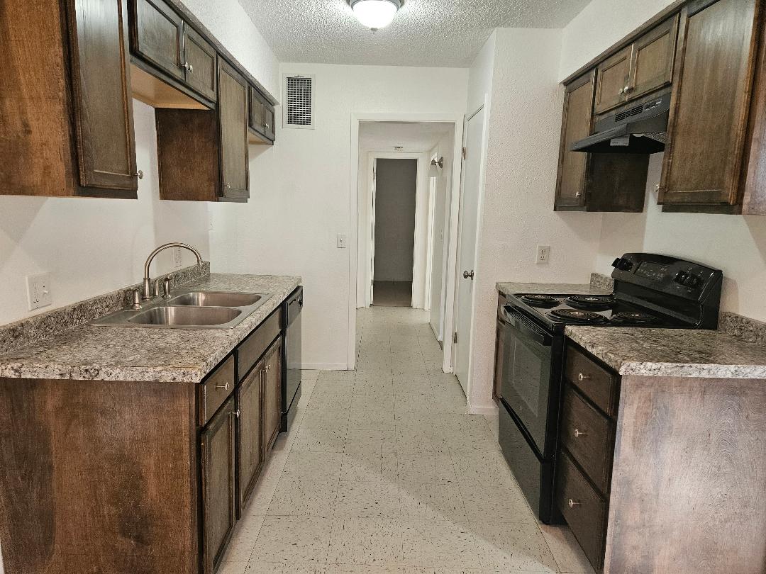 410 East 9th Street, Unit C Elgin, TX 78621 - Photo 3 of 11 a kitchen with granite countertop a sink and a stove top oven