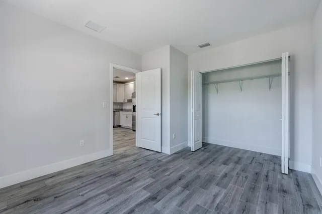 a view of empty room with wooden floor
