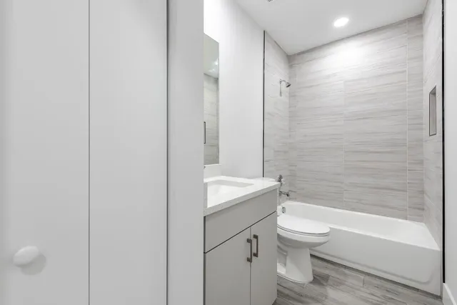 a bathroom with a granite countertop toilet a sink and bathtub