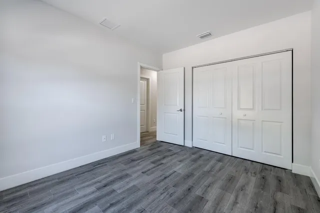 a view of an empty room with wooden floor