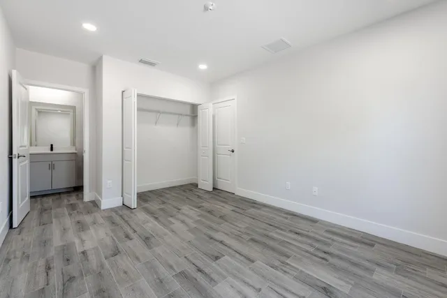 an empty room with wooden floor and mirror