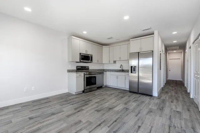 a kitchen with stainless steel appliances a refrigerator and a stove top oven