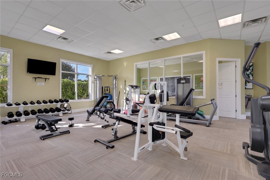 4210 Dutchess Park Road Fort Myers, FL 33916 - Photo 32 of 36 a living room with furniture gym equipment and a flat screen tv