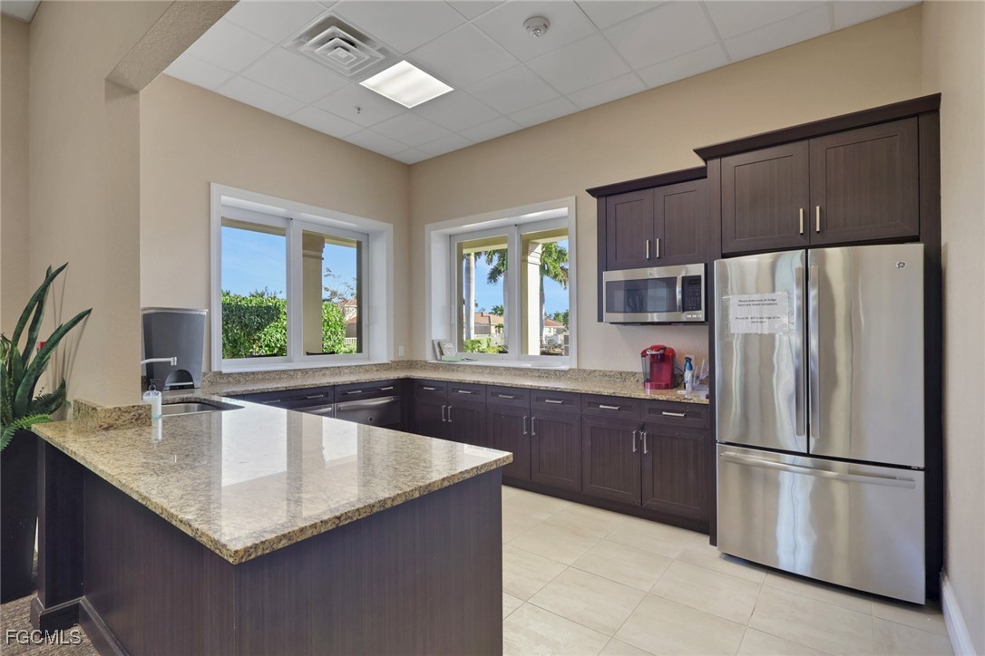 4210 Dutchess Park Road Fort Myers, FL 33916 - Photo 34 of 36 a kitchen with stainless steel appliances granite countertop a refrigerator a sink a stove a counter space and cabinets