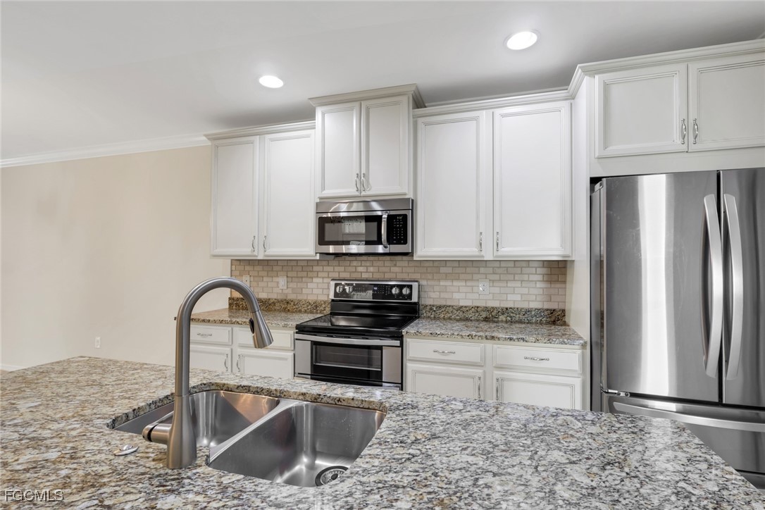 4210 Dutchess Park Road Fort Myers, FL 33916 - Photo 8 of 36 a kitchen with stainless steel appliances granite countertop a refrigerator sink and stove
