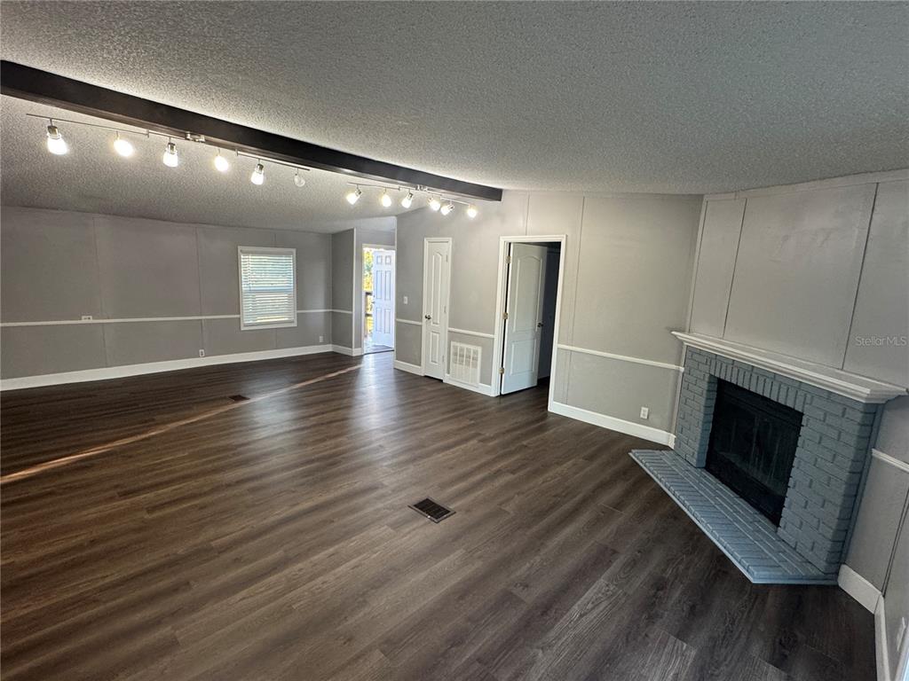 5254 Mt Olive Road Polk City, FL 33868 - Photo 11 of 19 a view of an empty room with wooden floor and a fireplace