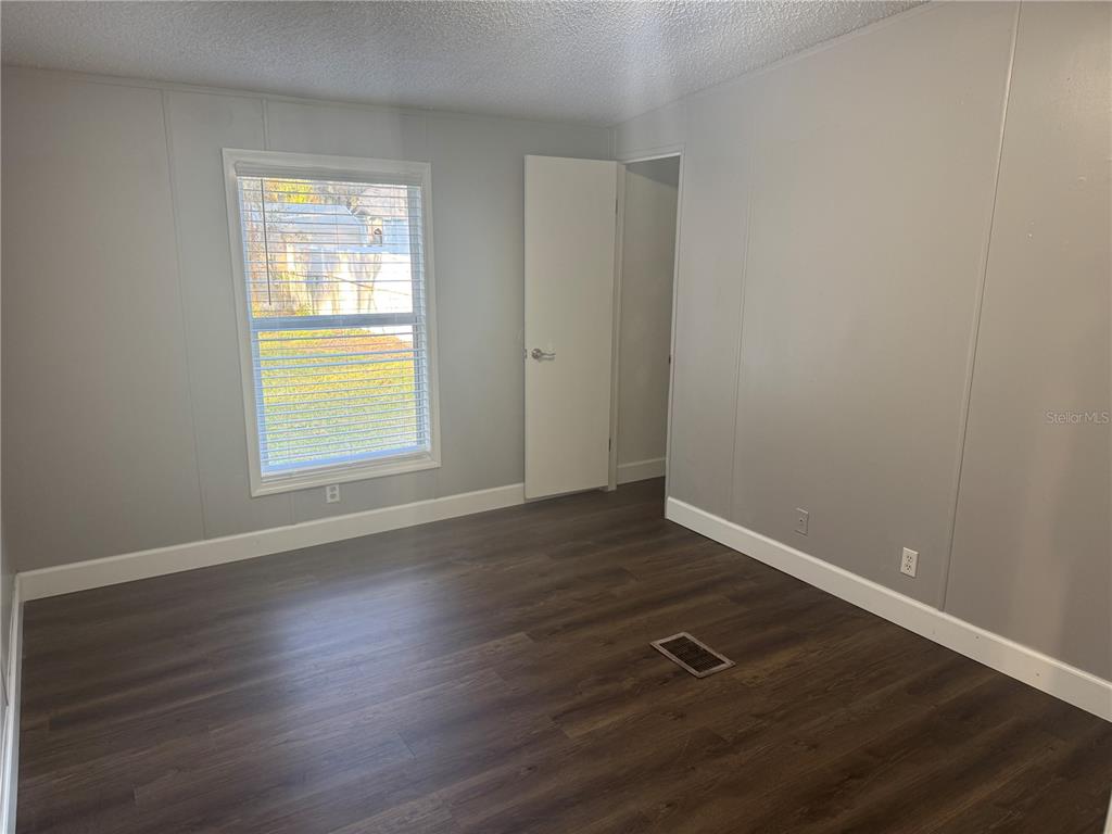 5254 Mt Olive Road Polk City, FL 33868 - Photo 16 of 19 an empty room with wooden floor and windows