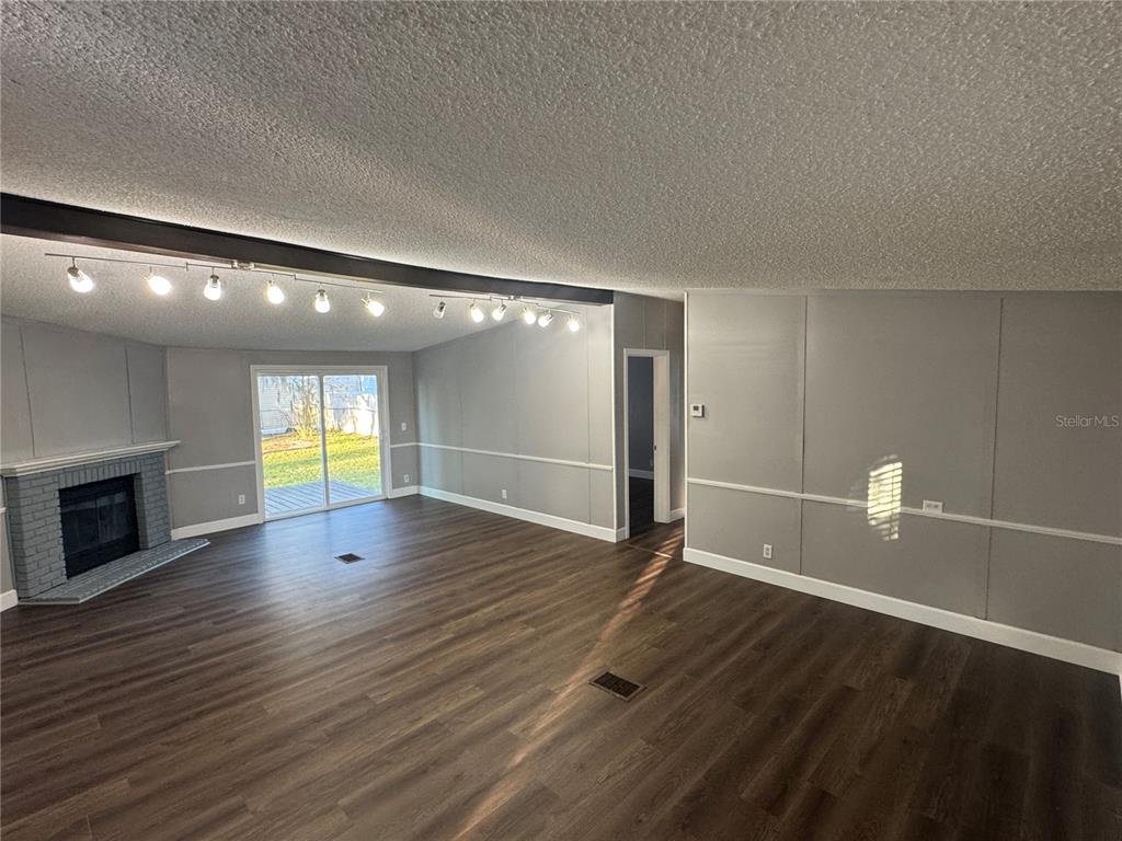 5254 Mt Olive Road Polk City, FL 33868 - Photo 9 of 19 a view of an empty room with wooden floor and a fireplace