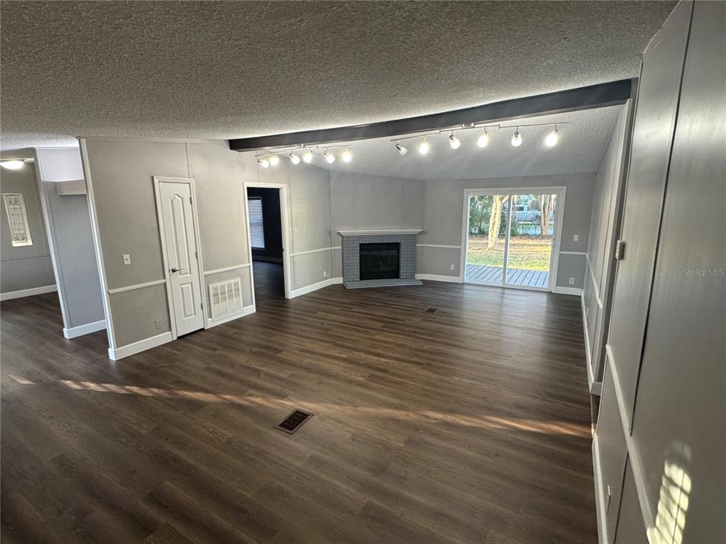 5254 Mt Olive Road Polk City, FL 33868 - Photo 10 of 19 an empty room with wooden floor and fireplace