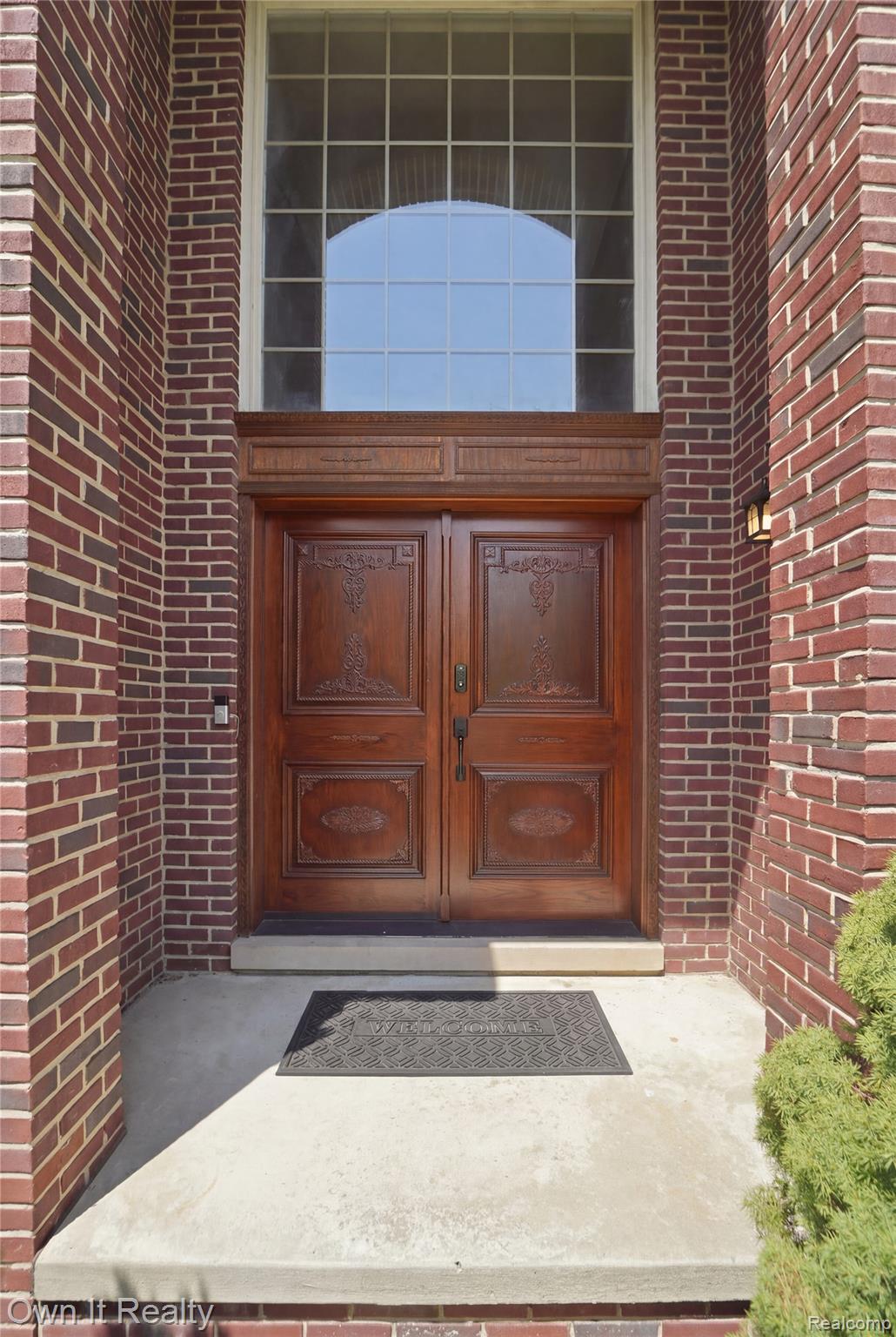 48280 Gladstone Road Canton, MI 48188 - Photo 6 of 59 Brick exterior showcasing an arched transom window above ornate double entry doors