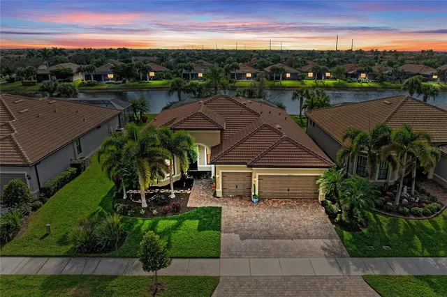a aerial view of a house with a garden and lake view