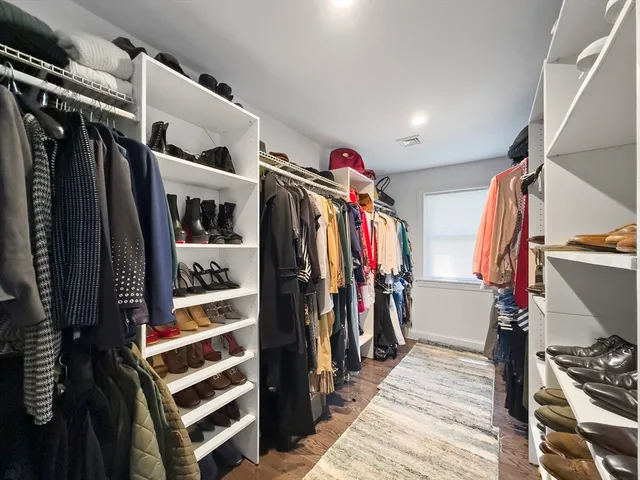 a view of walk in closet with clothes and shoes