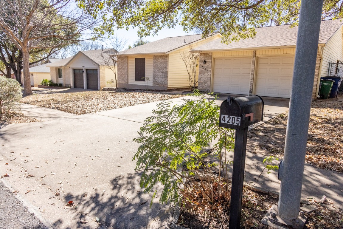 4205 Steve Scarbrough Drive Austin, TX 78759 - Photo 3 of 25 a front view of a house with a yard and garage