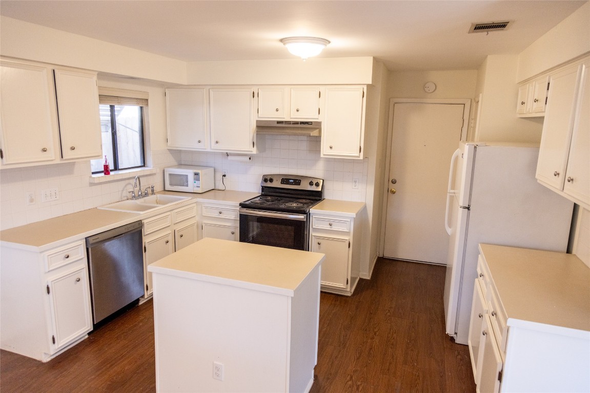 4205 Steve Scarbrough Drive Austin, TX 78759 - Photo 10 of 25 a kitchen with a sink a refrigerator a stove and wooden cabinets