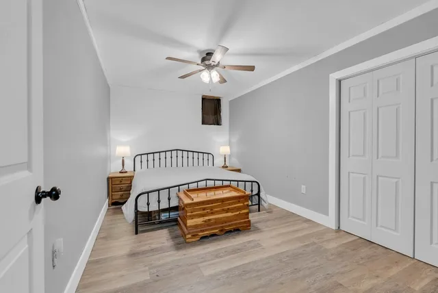 a living room with a ceiling fan and wooden floor