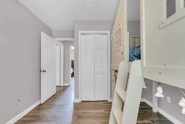 a view of a hallway with wooden floor and staircase