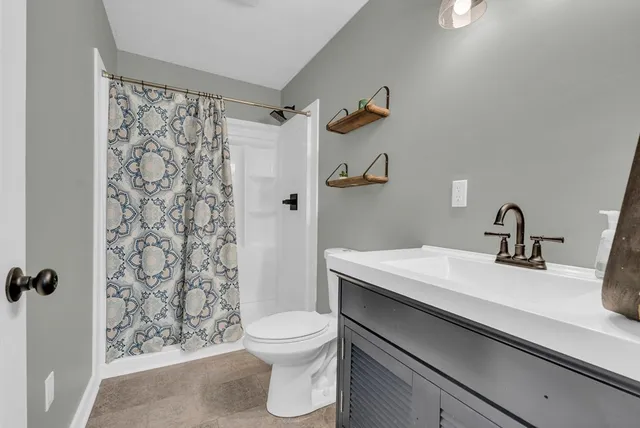 a bathroom with a toilet a sink and mirror