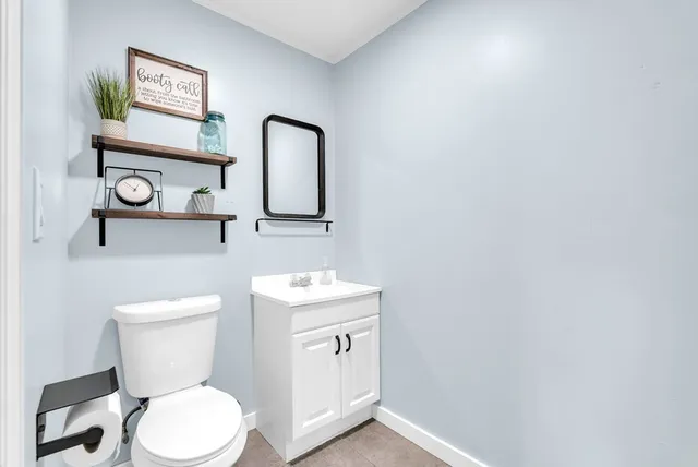 a view of a workspace with wooden floor and white cabinet
