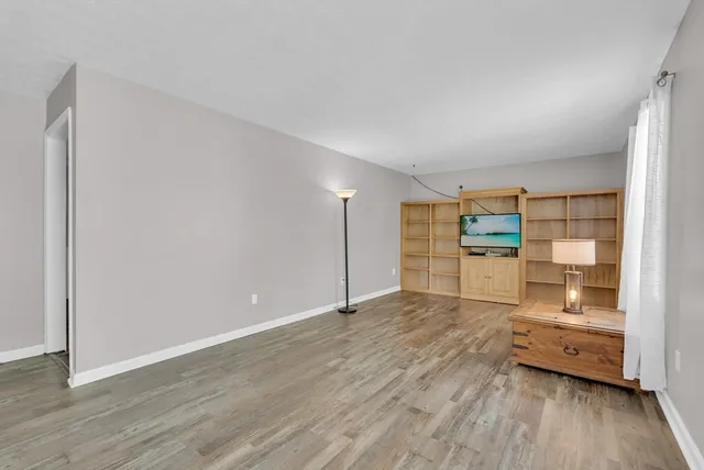 a view of a kitchen with wooden floor and electronic appliances