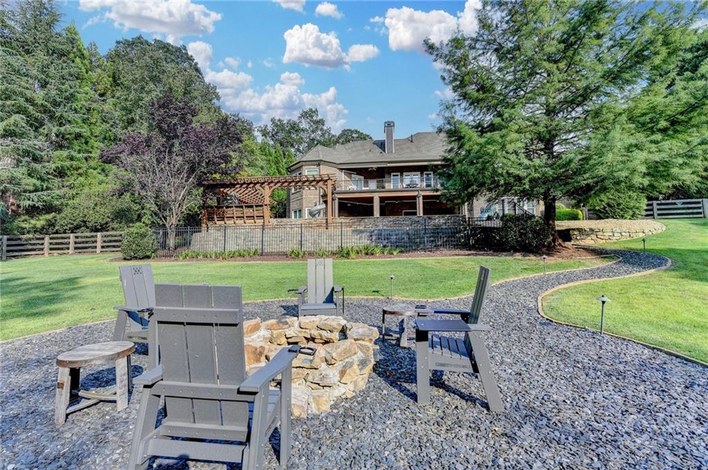 2850 Roanoke Road Cumming, GA 30041 - Photo 13 of 91 a view of a backyard with table and chairs potted plants and a big yard
