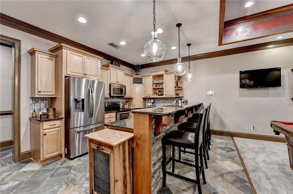 2850 Roanoke Road Cumming, GA 30041 - Photo 67 of 91 a kitchen with stainless steel appliances kitchen island granite countertop a refrigerator a stove a microwave oven a sink with island and chairs