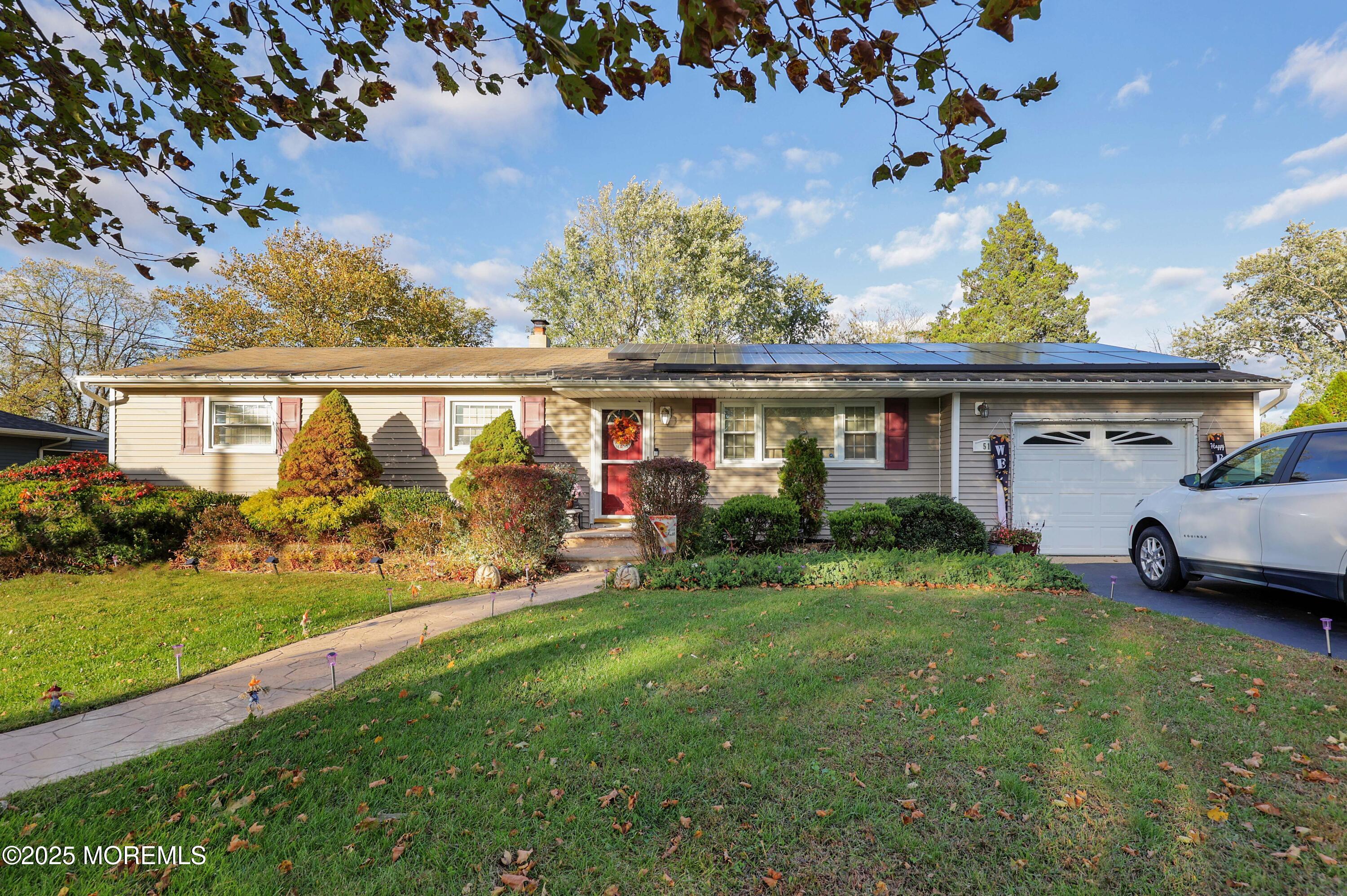 a view of a house with garden and a car park