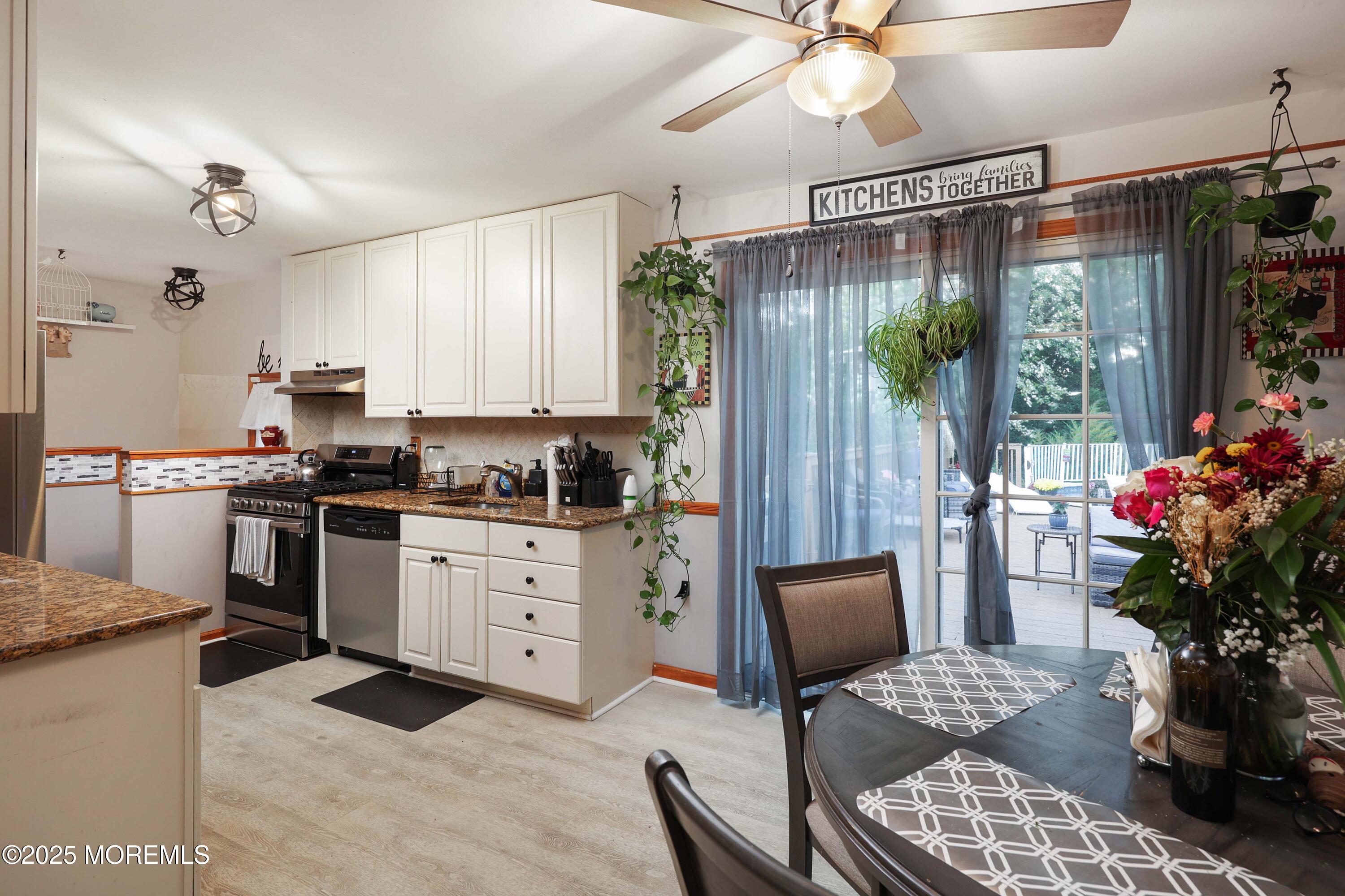 51 Alan Terrace Howell, NJ 07731 - Photo 11 of 32 a kitchen with stainless steel appliances kitchen island granite countertop a refrigerator a sink dishwasher a dining table and with potted plant