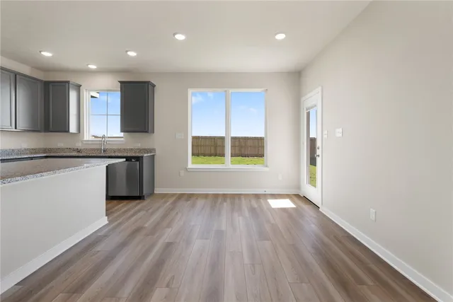 a view of kitchen with wooden floor and electronic appliances