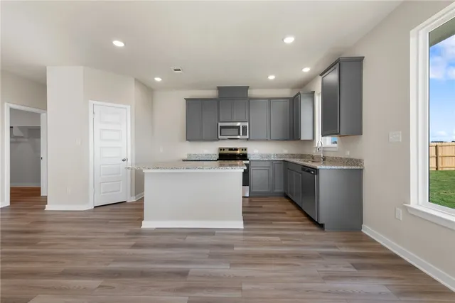 a kitchen with a refrigerator and a stove top oven