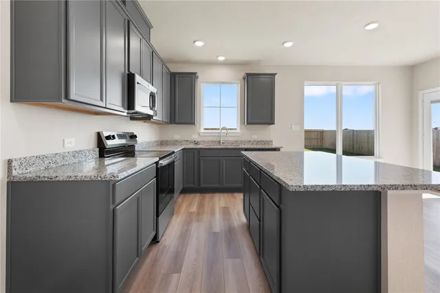 a kitchen with granite countertop stainless steel appliances and wooden cabinets