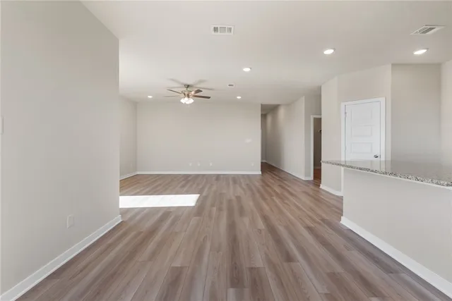 a view of wooden floor in an empty room with a window
