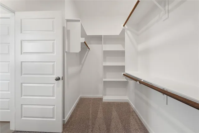 a view of walk in closet with empty racks
