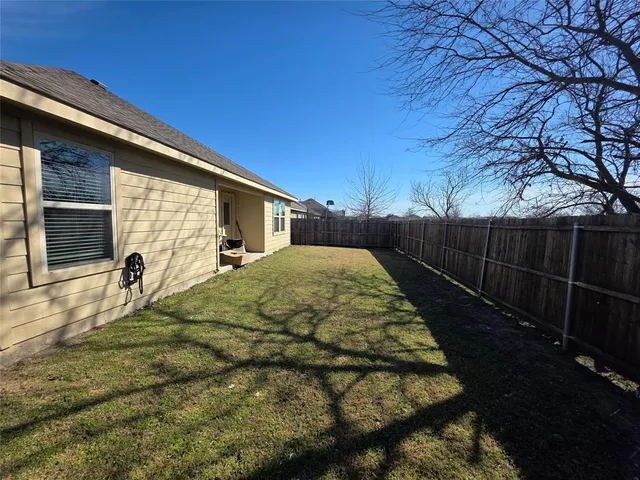 a view of a backyard with table and chairs with wooden fence