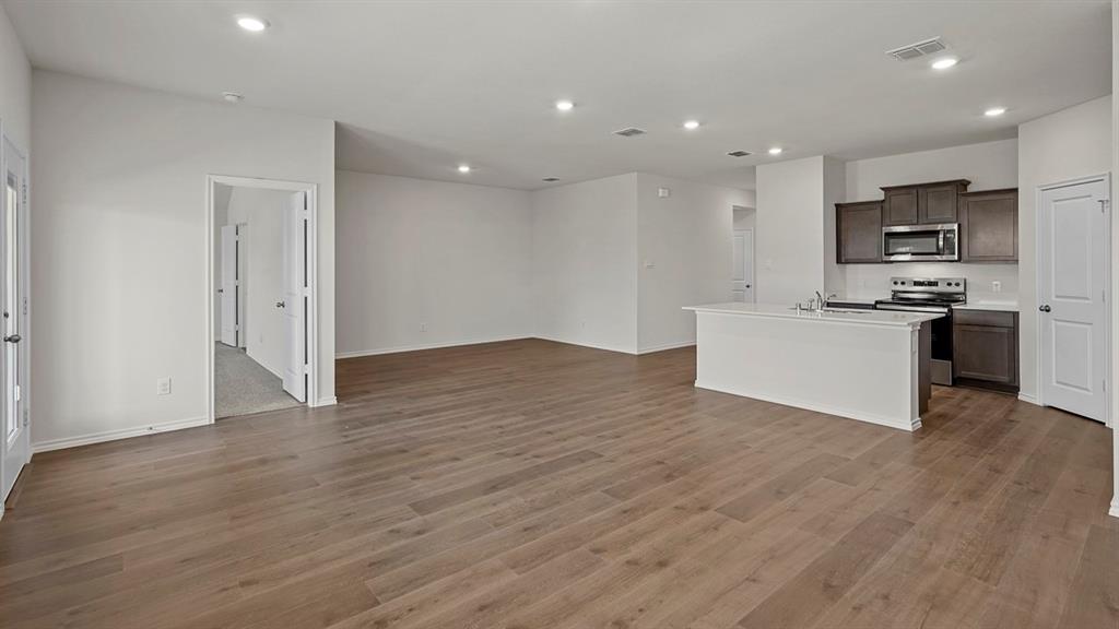 628 Dunham Road Farmersville, TX 75442 - Photo 29 of 36 Expansive room featuring wood-finish flooring, recessed lighting, and a kitchen island with integrated sink