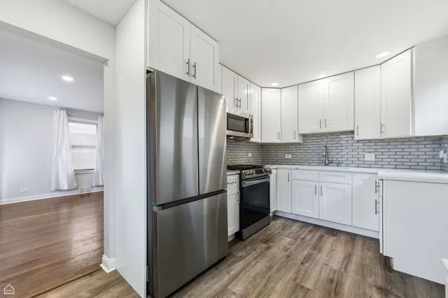 a kitchen with granite countertop stainless steel appliances a refrigerator a sink and cabinets