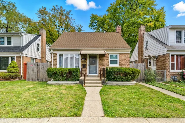 a front view of a house with a yard and potted plants