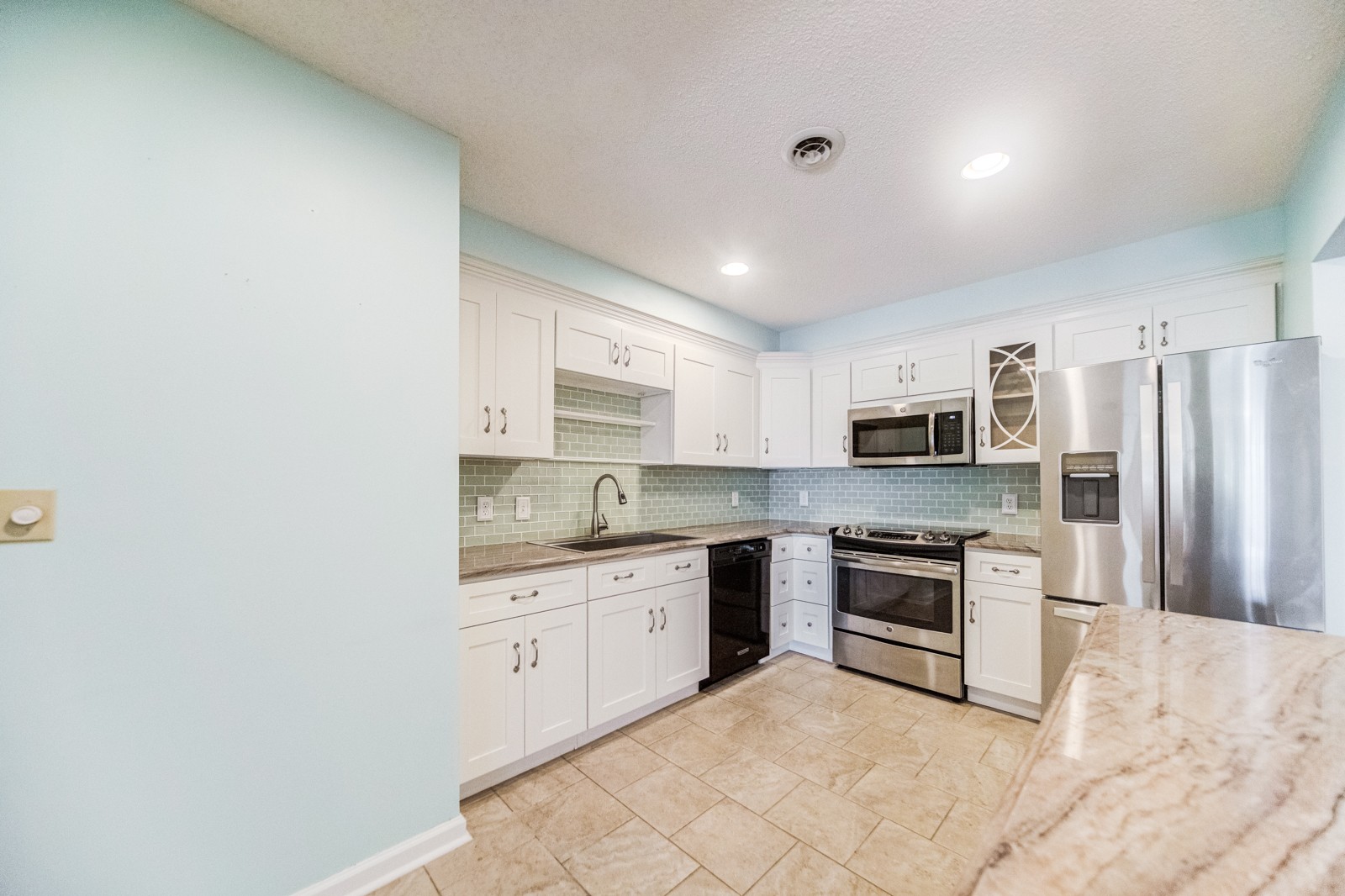 a kitchen with stainless steel appliances granite countertop a stove top oven a sink and dishwasher