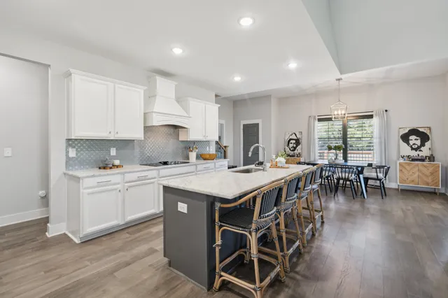 a kitchen with a dining table chairs refrigerator and cabinets
