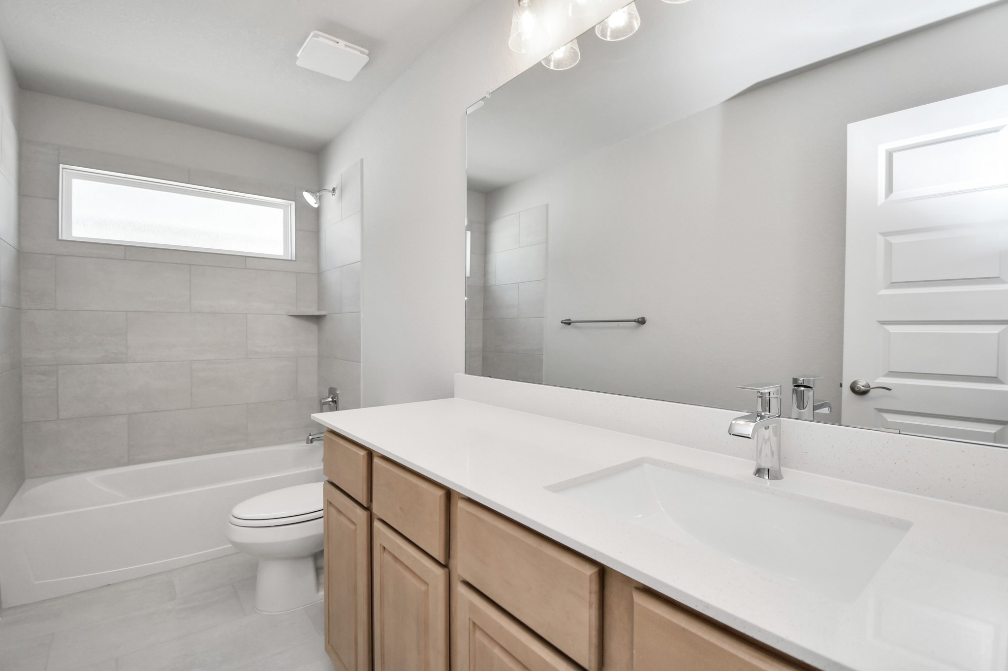 3038 Native Spg Drive Spring, TX 77373 - Photo 35 of 40 Secondary bath features tile flooring, bath/shower combo with tile surround, light stained wood cabinets, beautiful light countertop. Sample photo of completed home with similar floor plan. Actual colors and selections may vary.