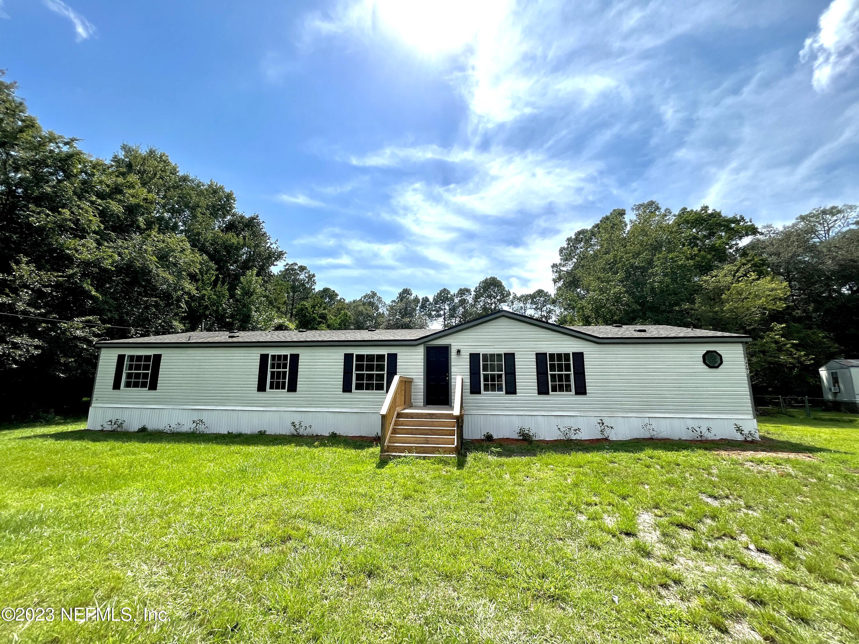 54291 Marlee Road Callahan, FL 32011 - Photo 1 of 7 a front view of house with yard and swimming pool