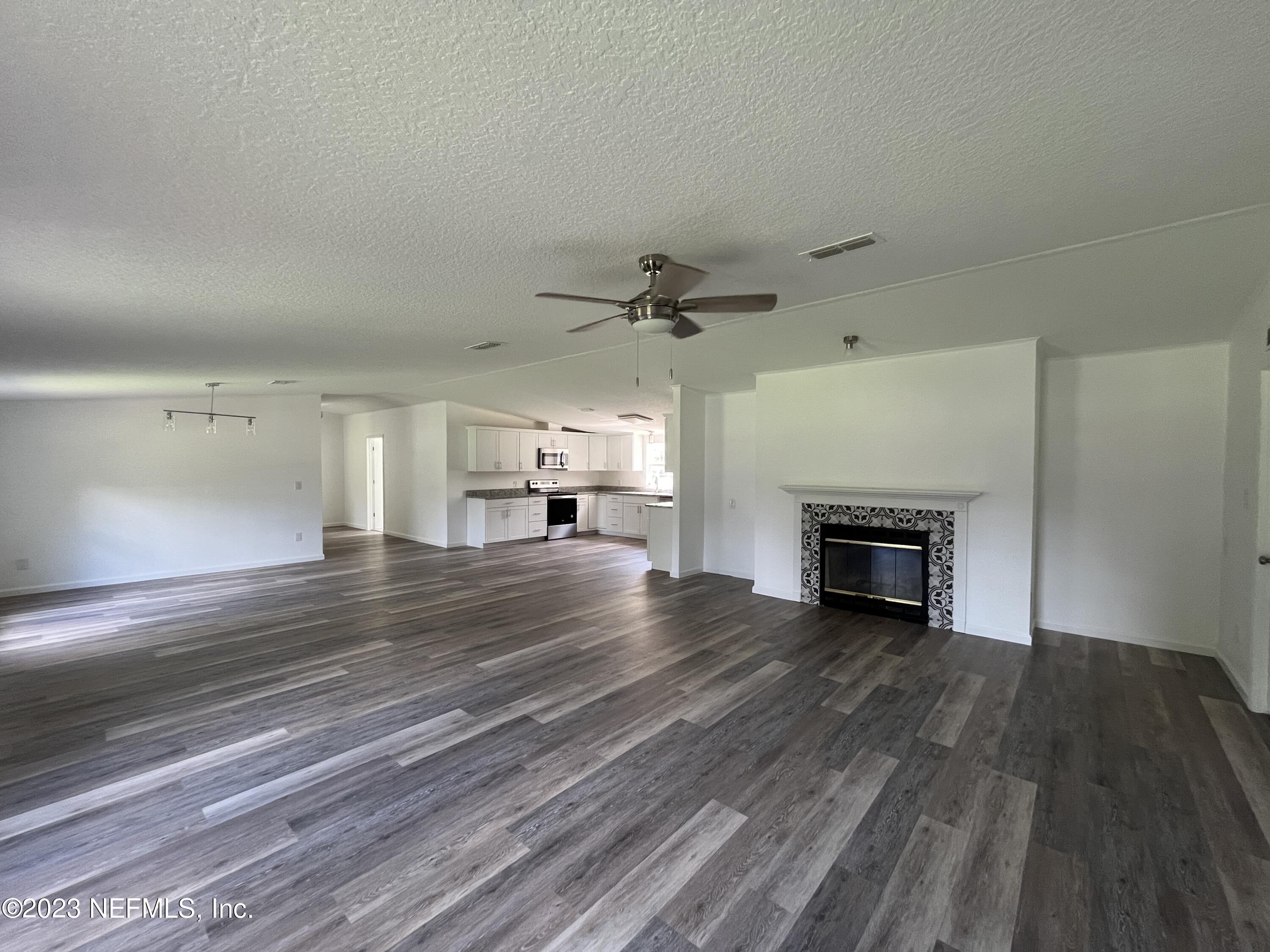 54291 Marlee Road Callahan, FL 32011 - Photo 6 of 7 a view of empty room with wooden floor fireplace and window