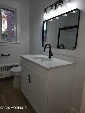 a bathroom with a sink a toilet and mirror