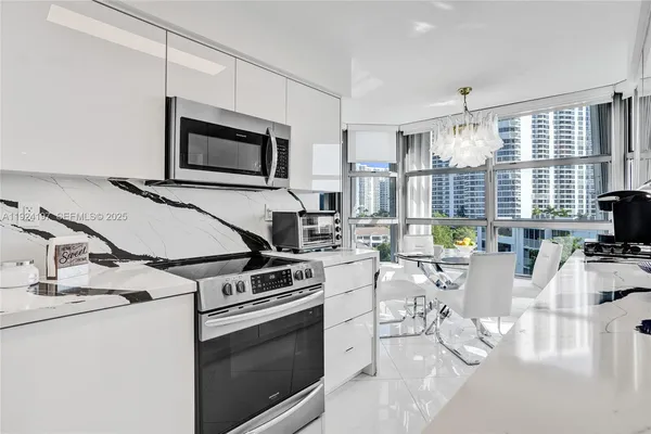 a kitchen with stainless steel appliances a stove a refrigerator cabinets and a dining table